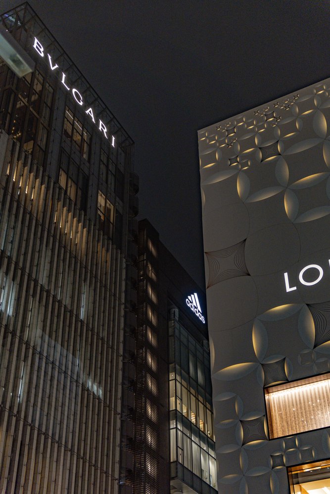 Bvlgari tower and Louis Vuitton building lit up at night in Ginza, Tokyo — Zen Den Studios