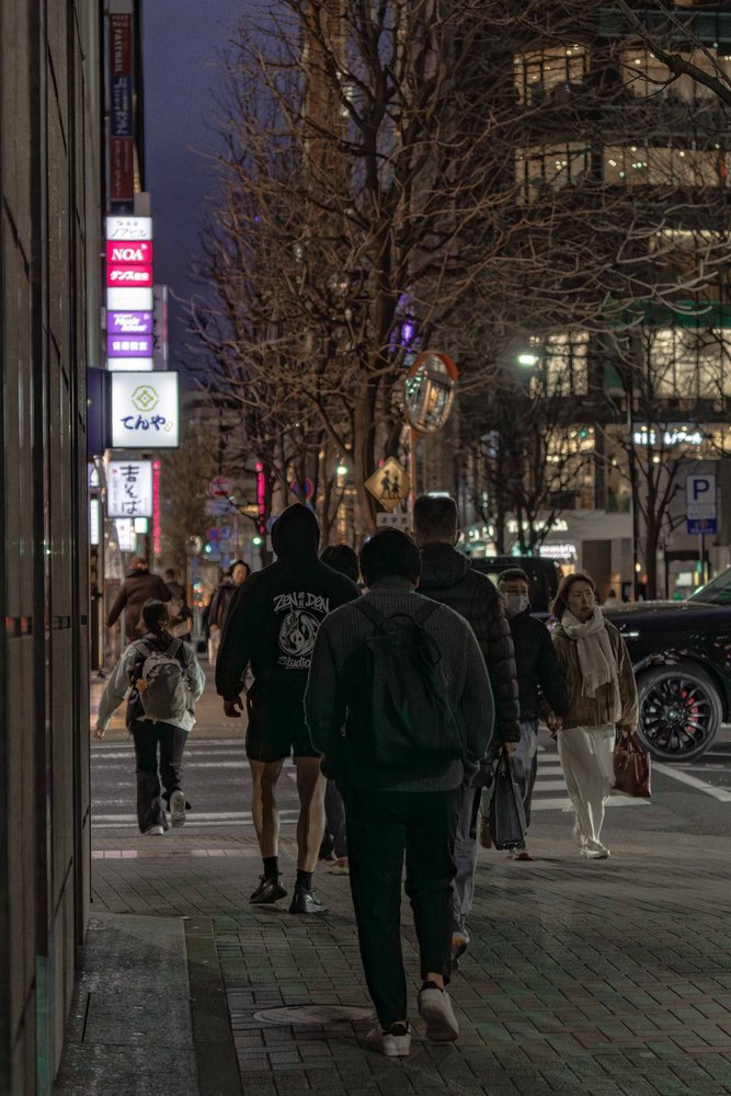 Group walking down a busy Tokyo street at night wearing Zen Den Studios hoodies — Zen Den Studios